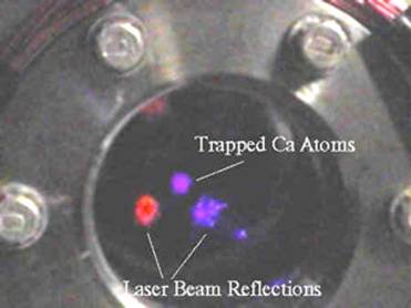 Photo showing blue fluorescence from trapped atoms - also seen are reflections from the vacuum system window of a blue trapping beam and a red probe beam.