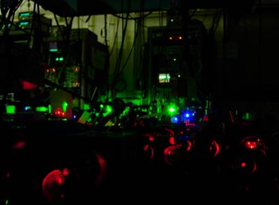 Photograph of the calcium optical clock experiment.  Clearly seen are the red, green, and blue laser colors used in these experiments.